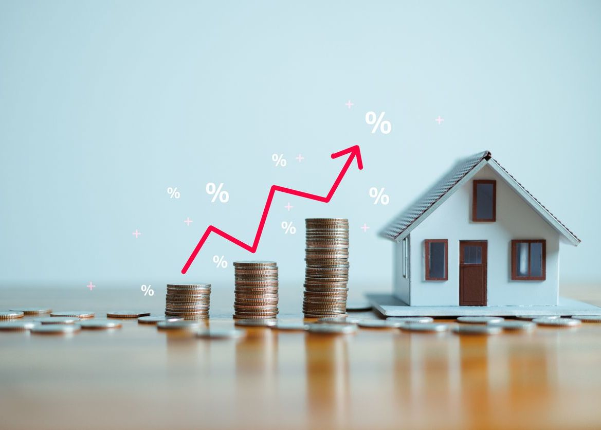Miniature house beside stacked coins and rising percentage arrow symbolizing homeowners insurance value and property protection in Arlington Heights IL